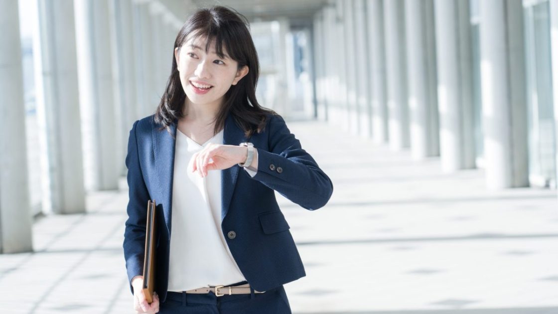 笑顔で歩くスーツ姿の女性