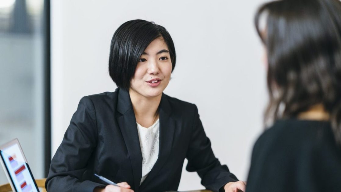資料の説明をするスーツを着た女性