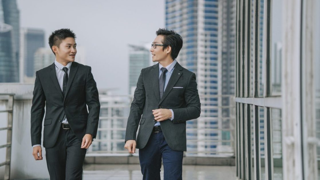並んで外を歩く二人のビジネスマン