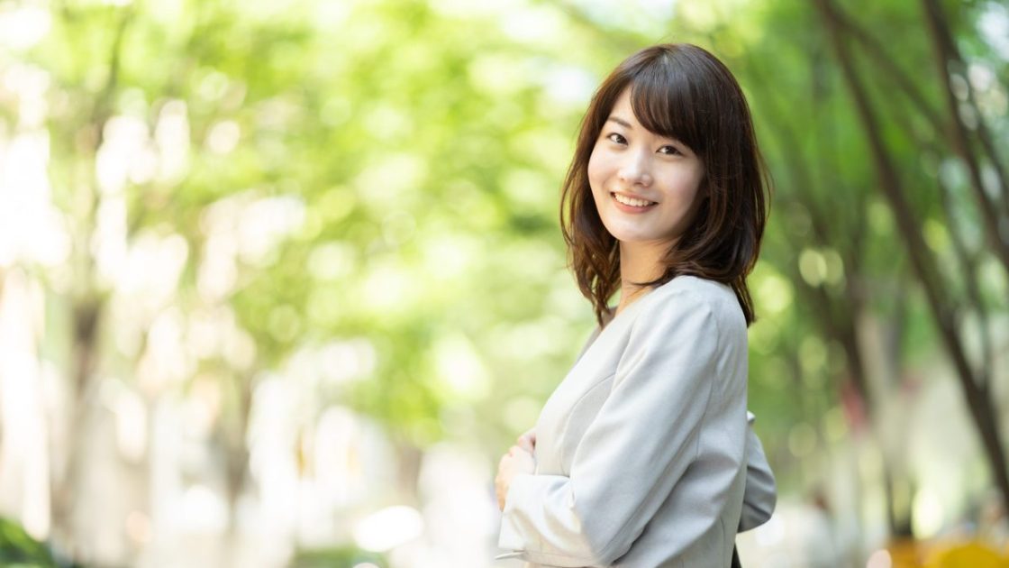 振り返って微笑むスーツ姿の女性