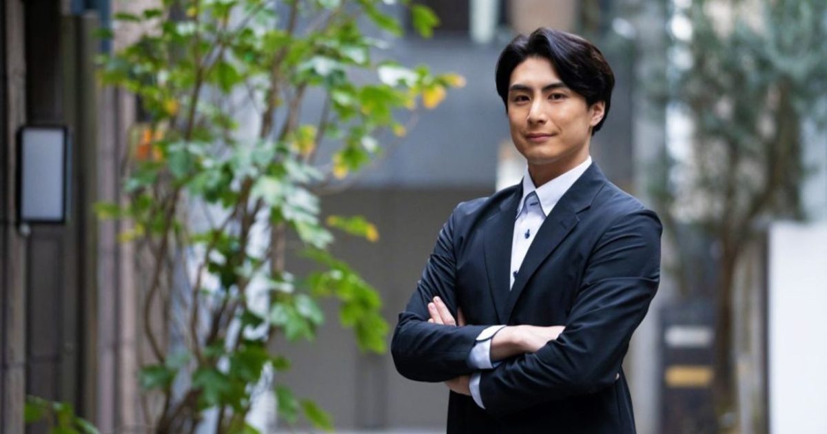 腕を組んで外に立っているビジネスマン