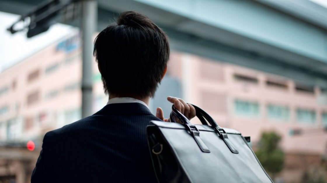 ビジネスバッグを持った男性の後ろ姿