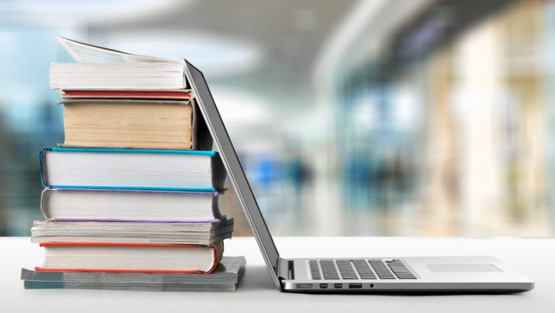 ノートパソコンと積み上げられた本