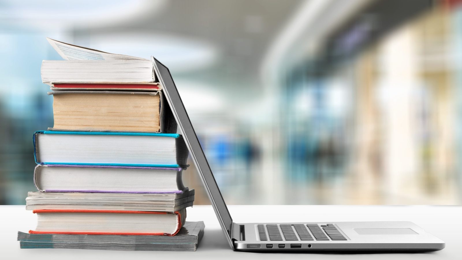 ノートパソコンと積み上げられた本