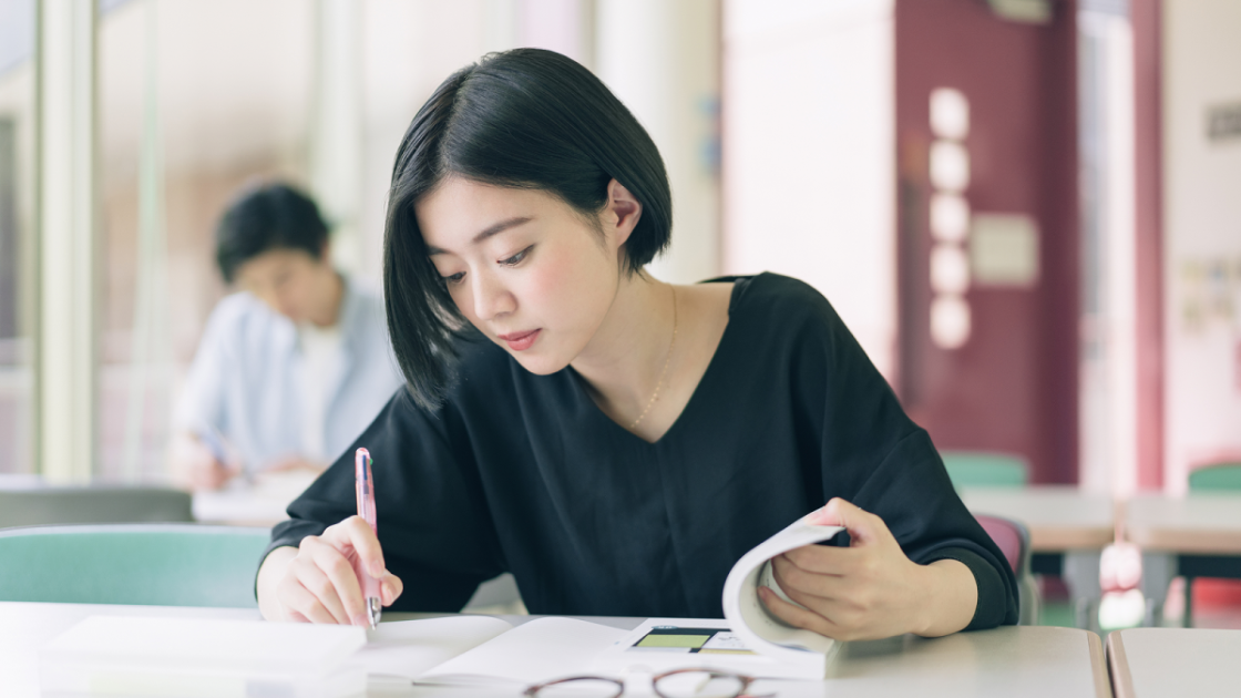 参考書を広げて勉強する女性