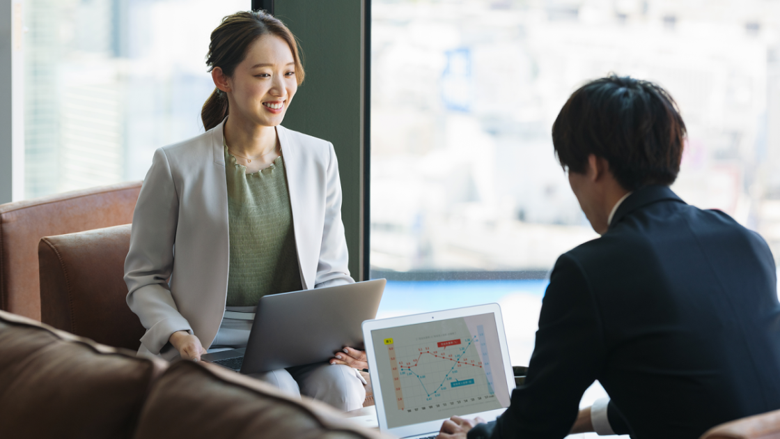 ノートパソコンを開いたまま話し合う男女