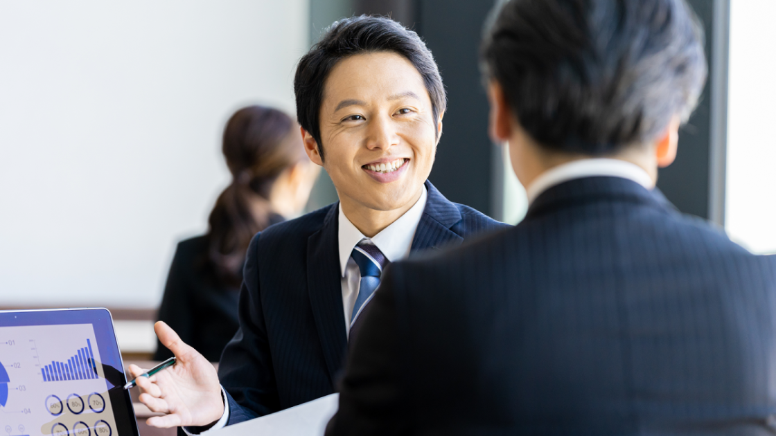 笑顔で商談相手に話しかけるビジネスマン
