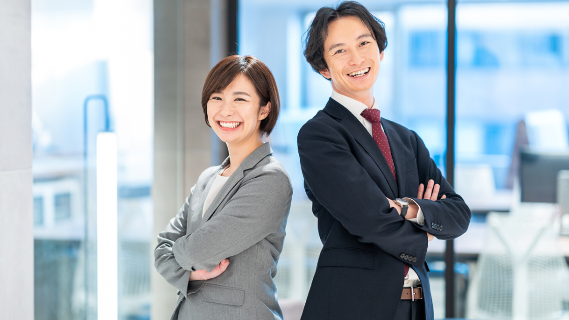 背中合わせで立っているスーツ姿の男女