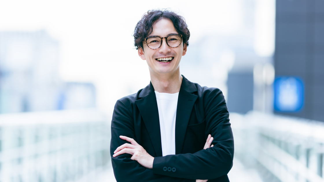 腕を組んで笑っている男性