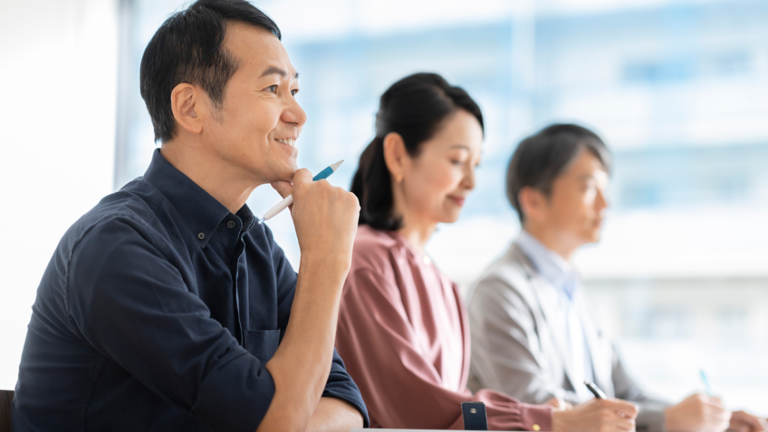 顎に手を当てながら話を聞く男性