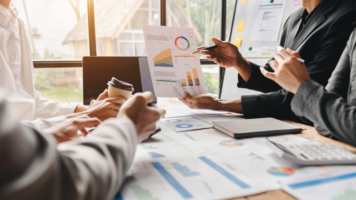 コーヒーを飲みながら資料を見て話し合う様子