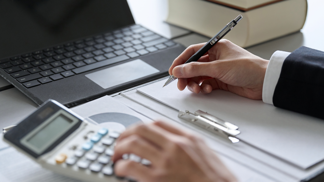 ノートにメモをとりながら電卓を叩く様子