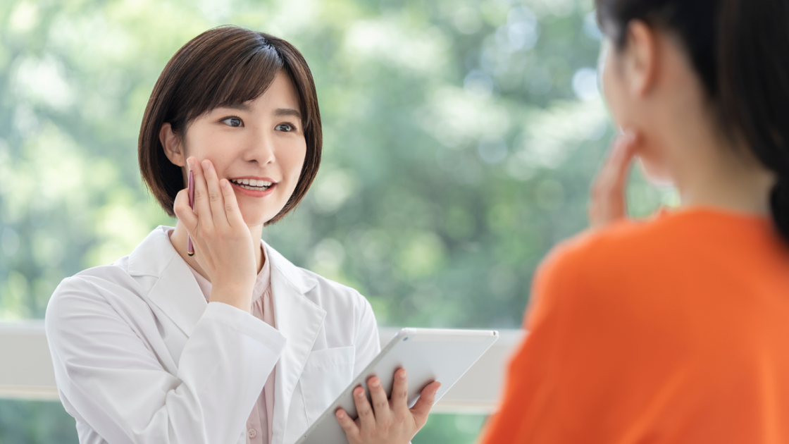 タブレットを持ってカウンセリングする女性