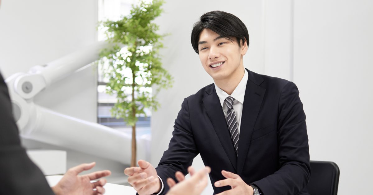 和やかな雰囲気で話すスーツ姿の男性