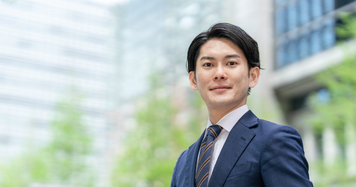 オフィス街に立つスーツを着た男性