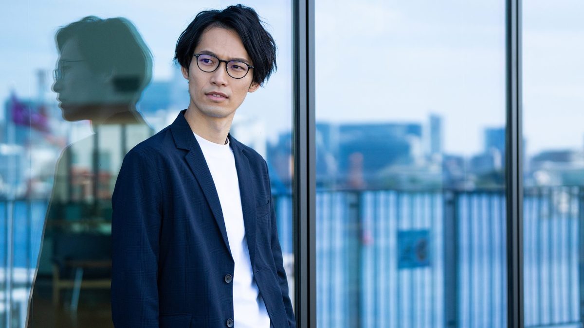 オフィスの窓に寄りかかる男性