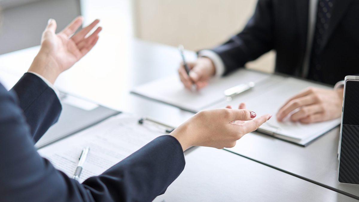 机に紙の資料を置いて話し合う様子