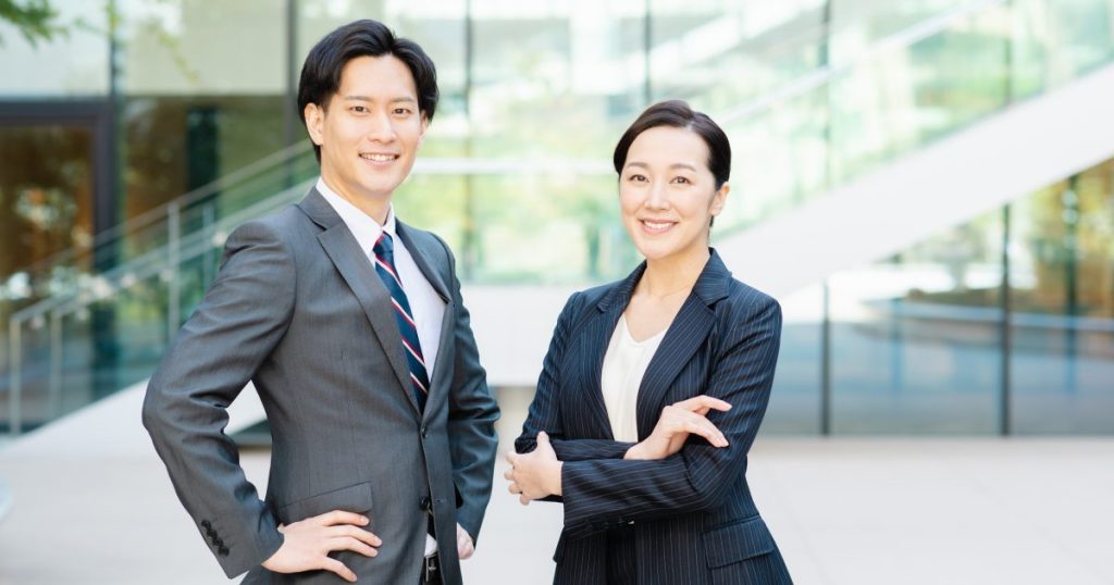 腰に手を当てた男性と腕を組んだ女性