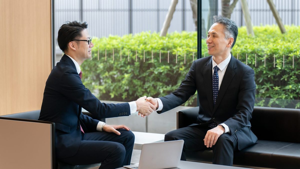 握手をするスーツ姿の二人の男性