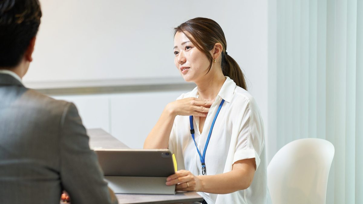 胸に手を当てながら話す女性