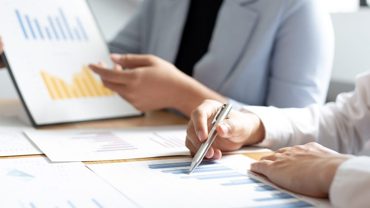 ボールペンで紙の資料に書き込む様子