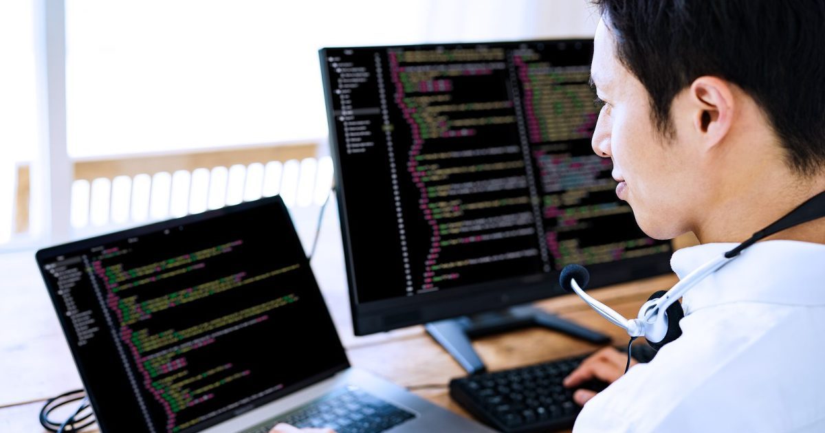 プログラミングをする男性の後ろ姿