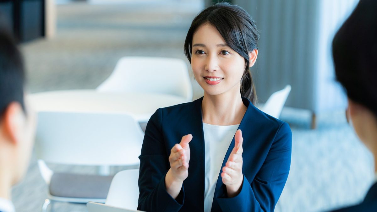 A woman in a suit talking with hand gestures