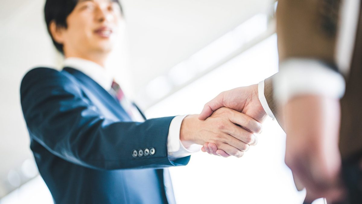 A low-angle view of a handshake
