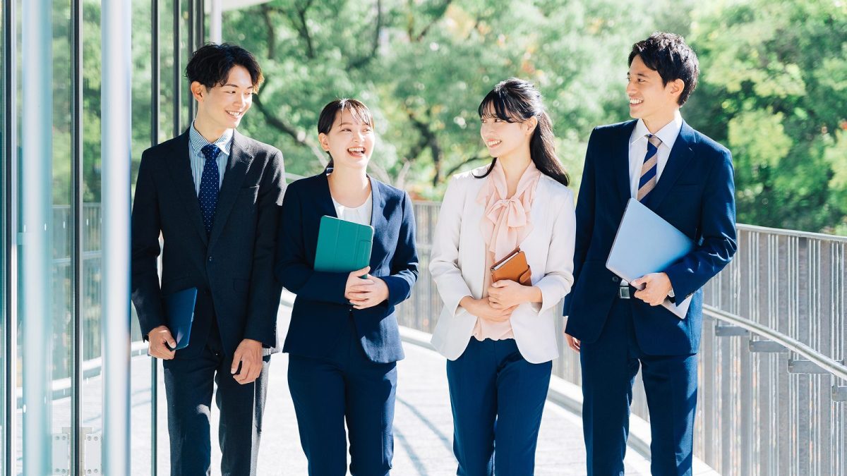 オフィスの外を歩くスーツを着た男女