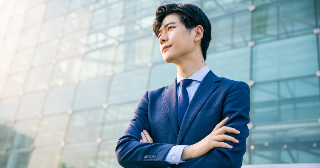 腕組みをするスーツの男性