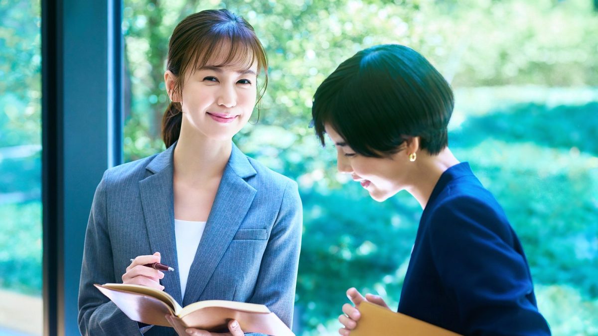 ノートを開いて話す二人の女性