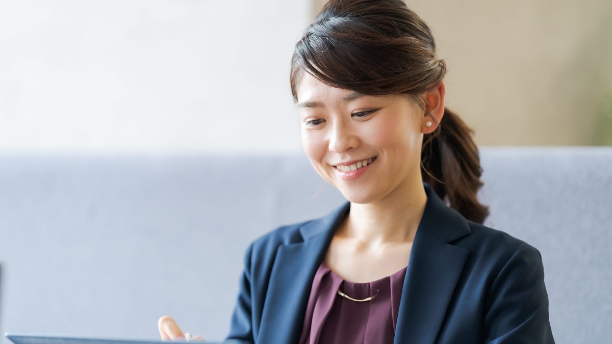バインダーにメモを取る笑顔の女性