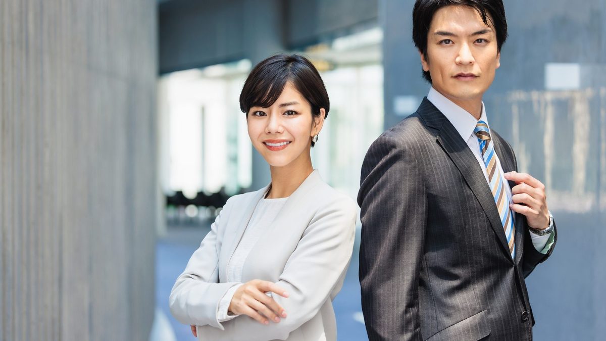オフィスに背中合わせで立つ男女