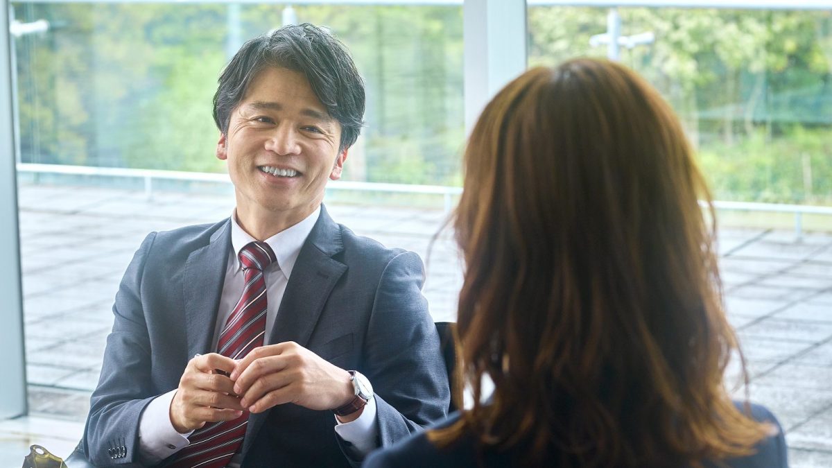 オフィスのロビーで話す中年の男性