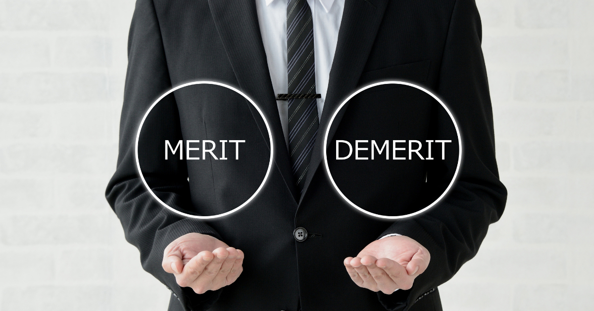 MERITとDEMERITの文字を手のひらにのせている男性