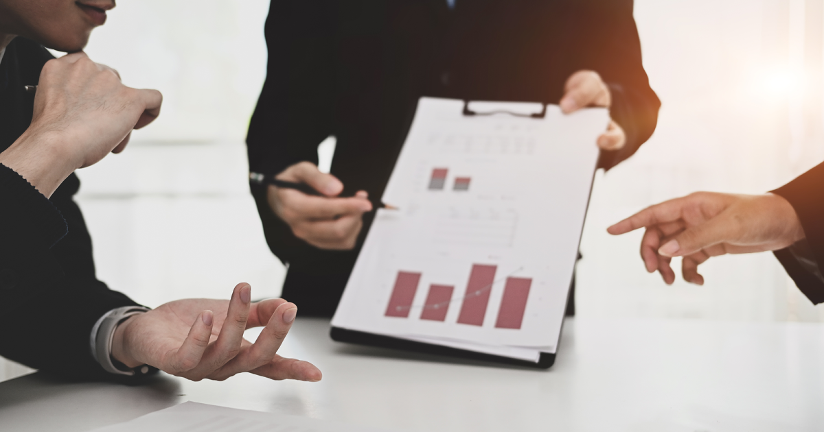 バインダーに挟んだ資料を指さして説明する様子