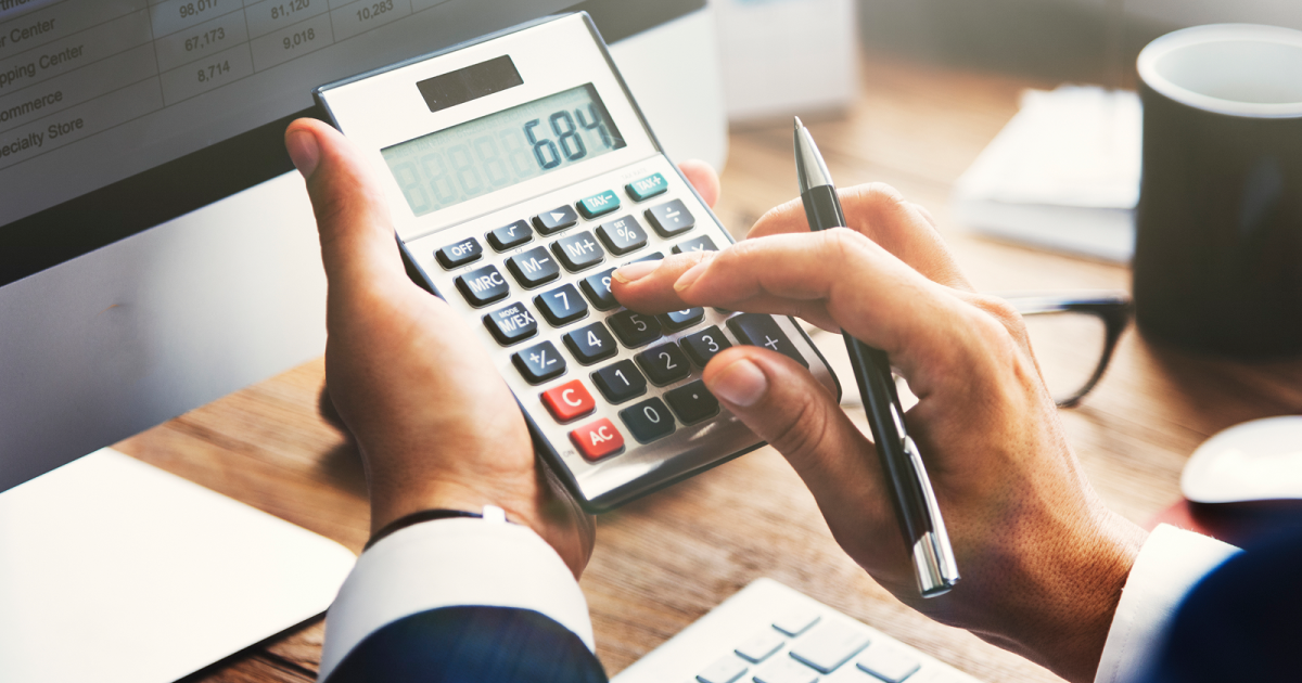 パソコンの前で電卓を操作する様子