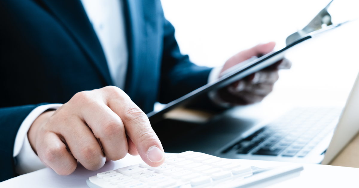 資料を見ながら電卓を打つ男性