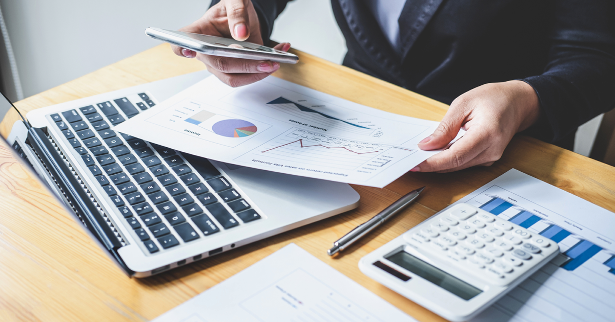 スマートフォンを操作しながら紙の資料を見る様子