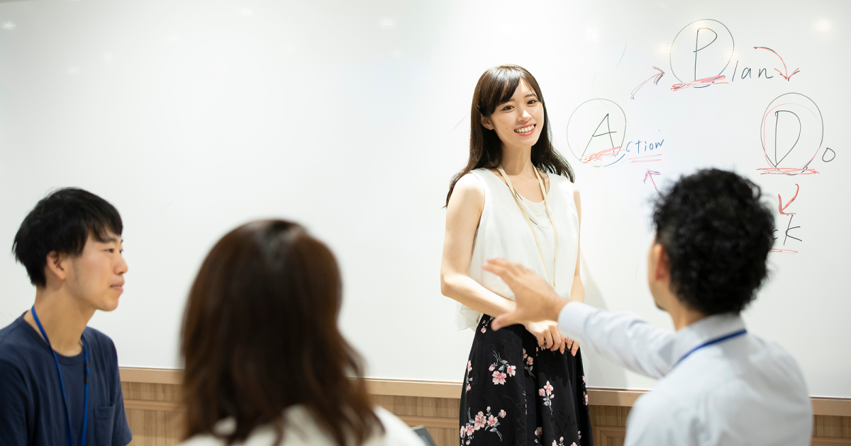 PDCAサイクルの説明をする女性