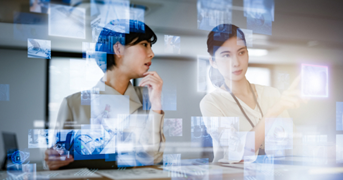 紙の資料を机に並べて分析をする女性