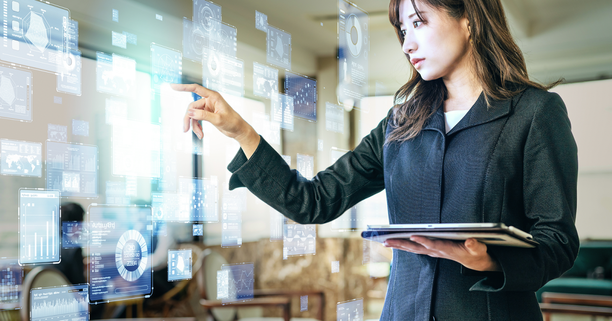 タブレットを片手に持ってデータ分析をする女性