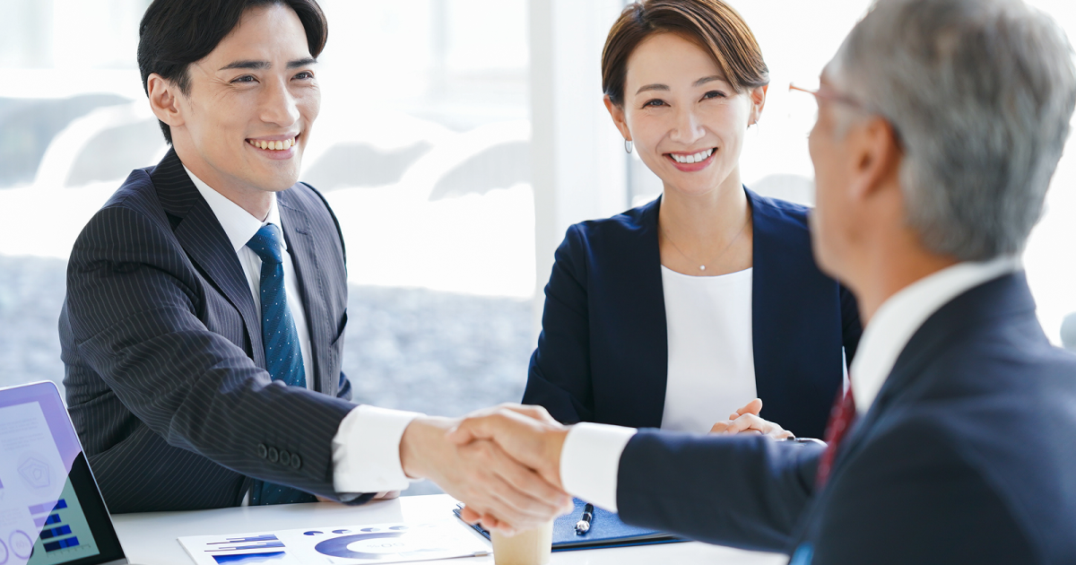 笑顔で握手を交わす二人の男性