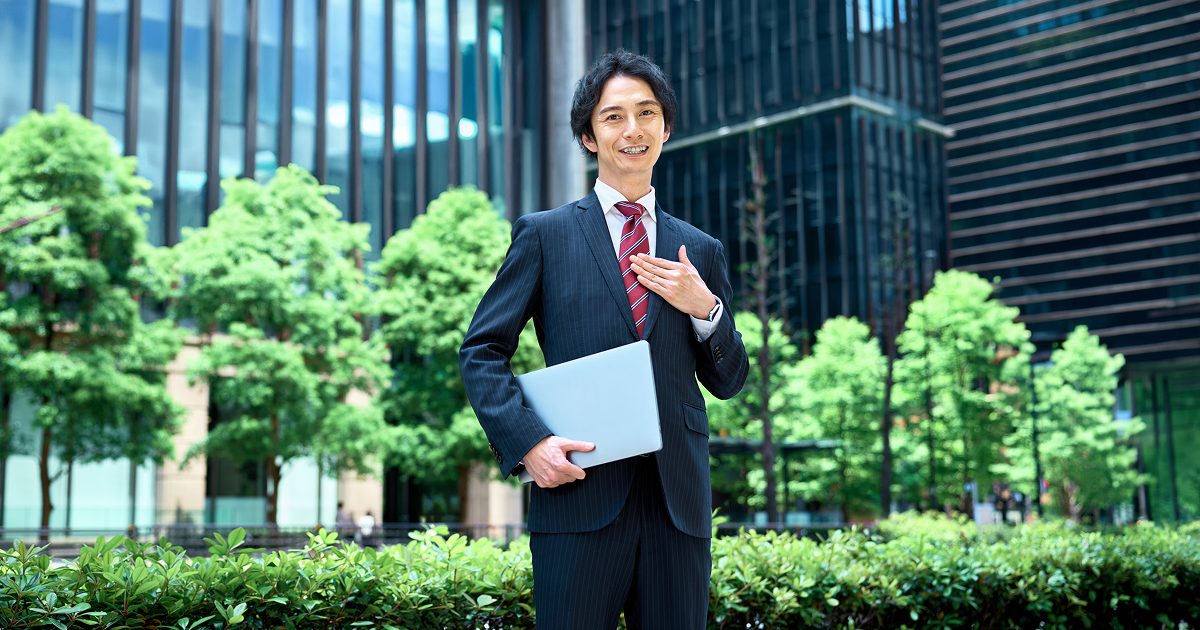 胸に手を当てる男性