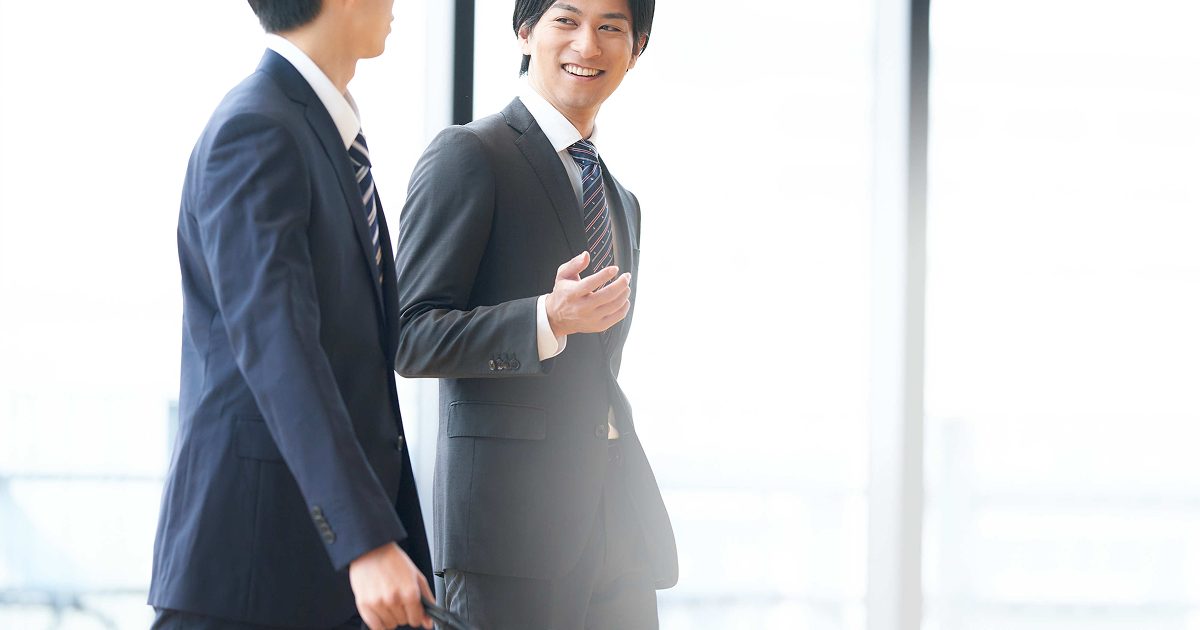 オフィスを歩きながら談笑する二人の男性