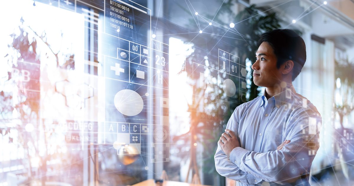 腕を組んでデータを見る男性