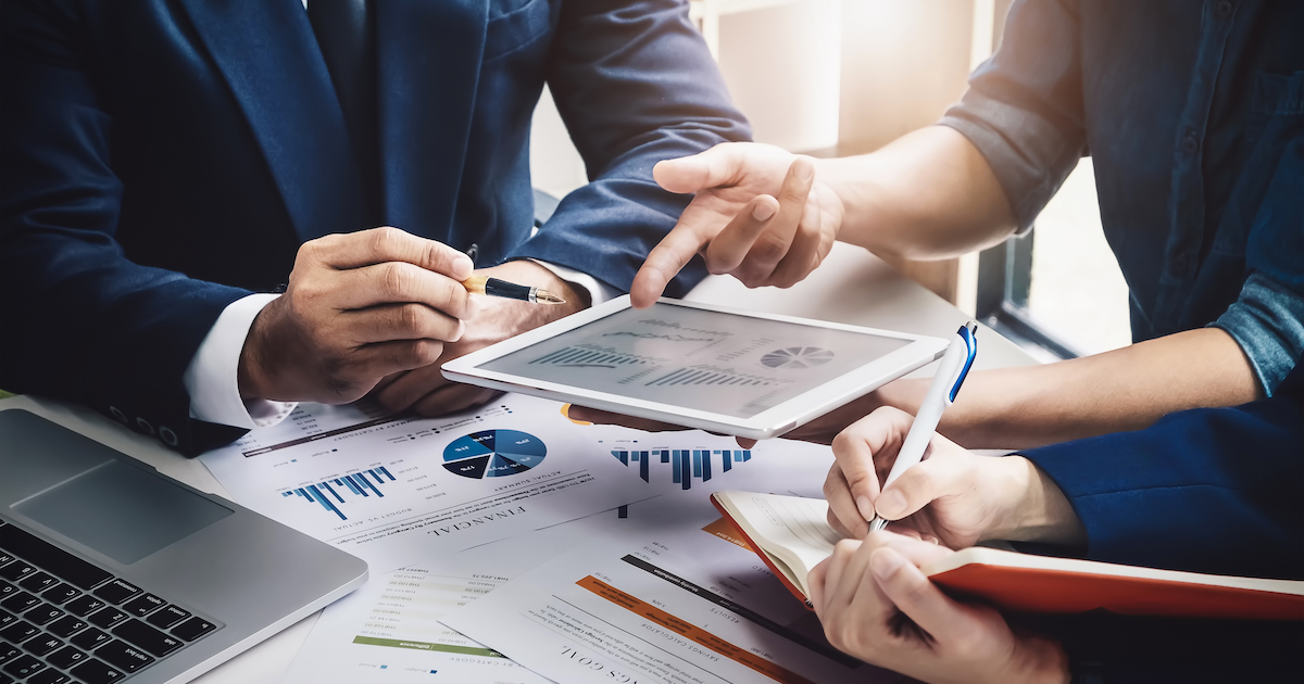 資料を机に広げて議論を交わす