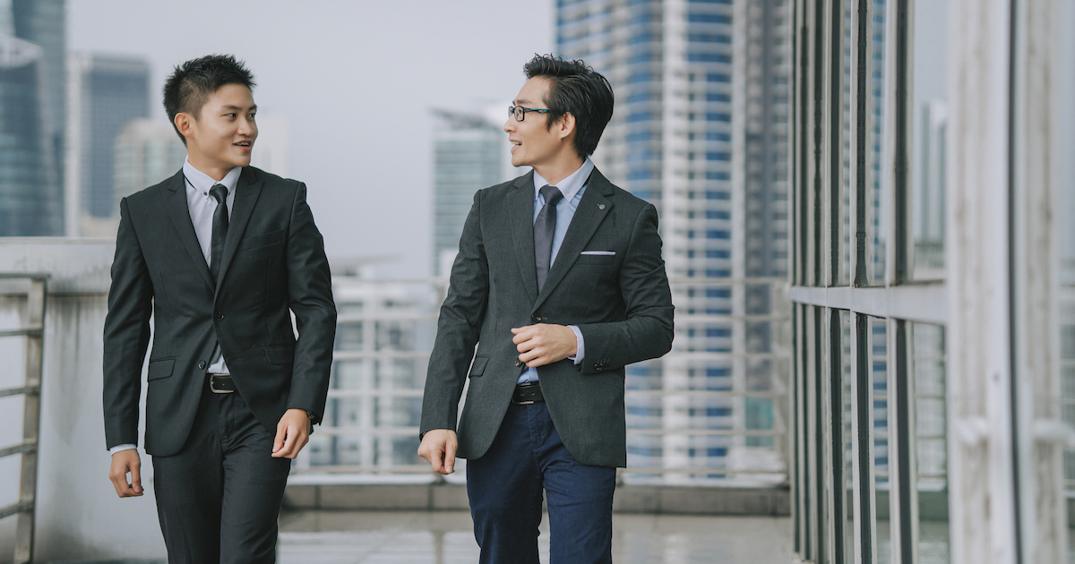 ビルの屋外で談笑する2人の男性