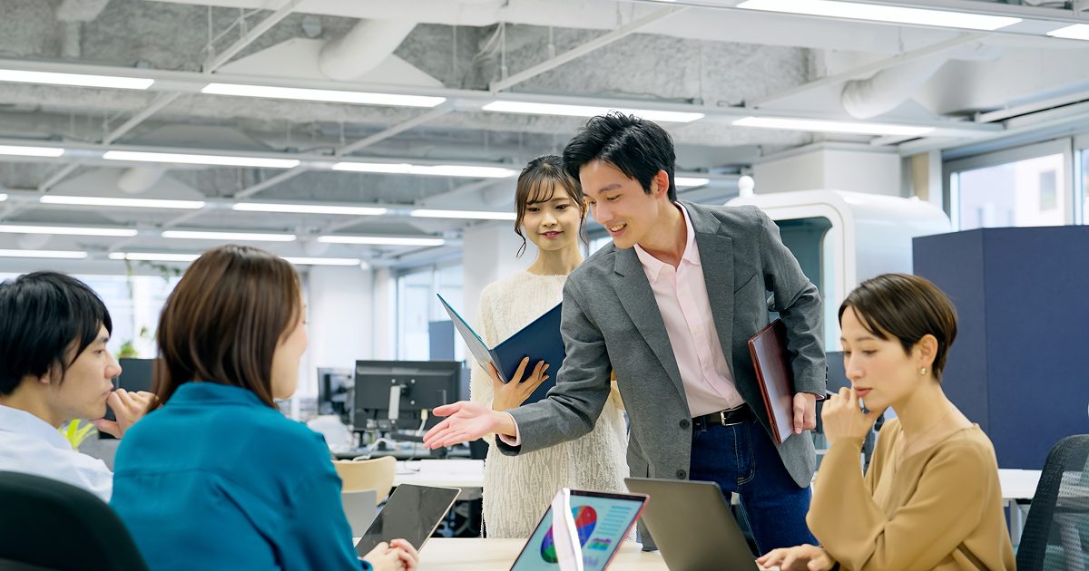 オフィスでラフに話す男女