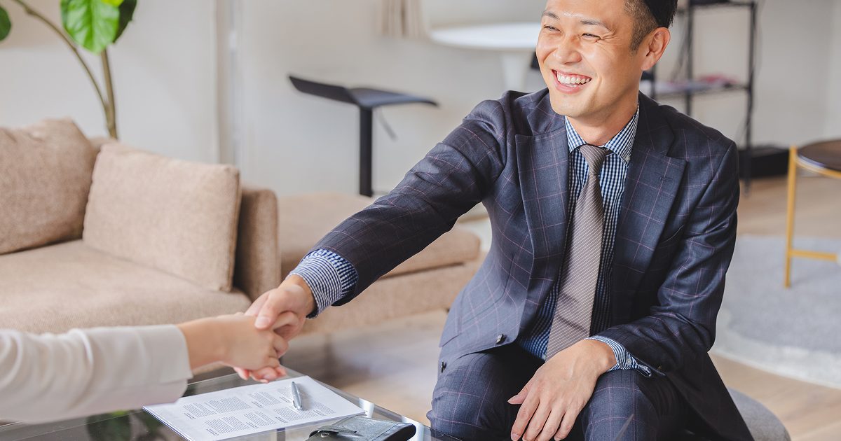 笑顔で握手をするスーツ姿の男性